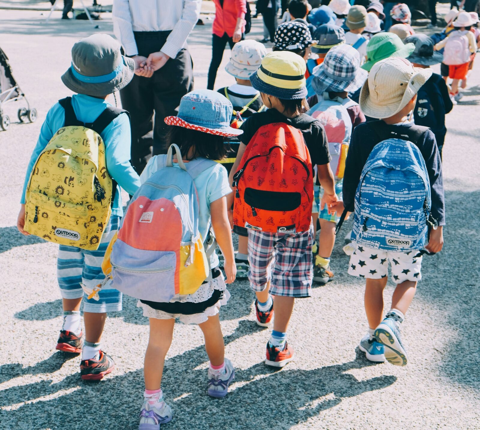 Children with backpacks walking ahead.
