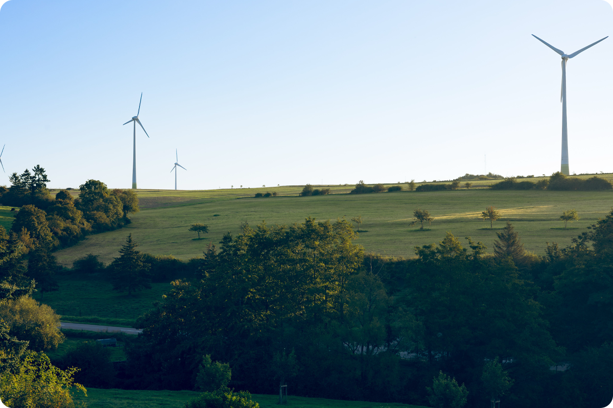 A countryside landscape with wind turbines on the hills